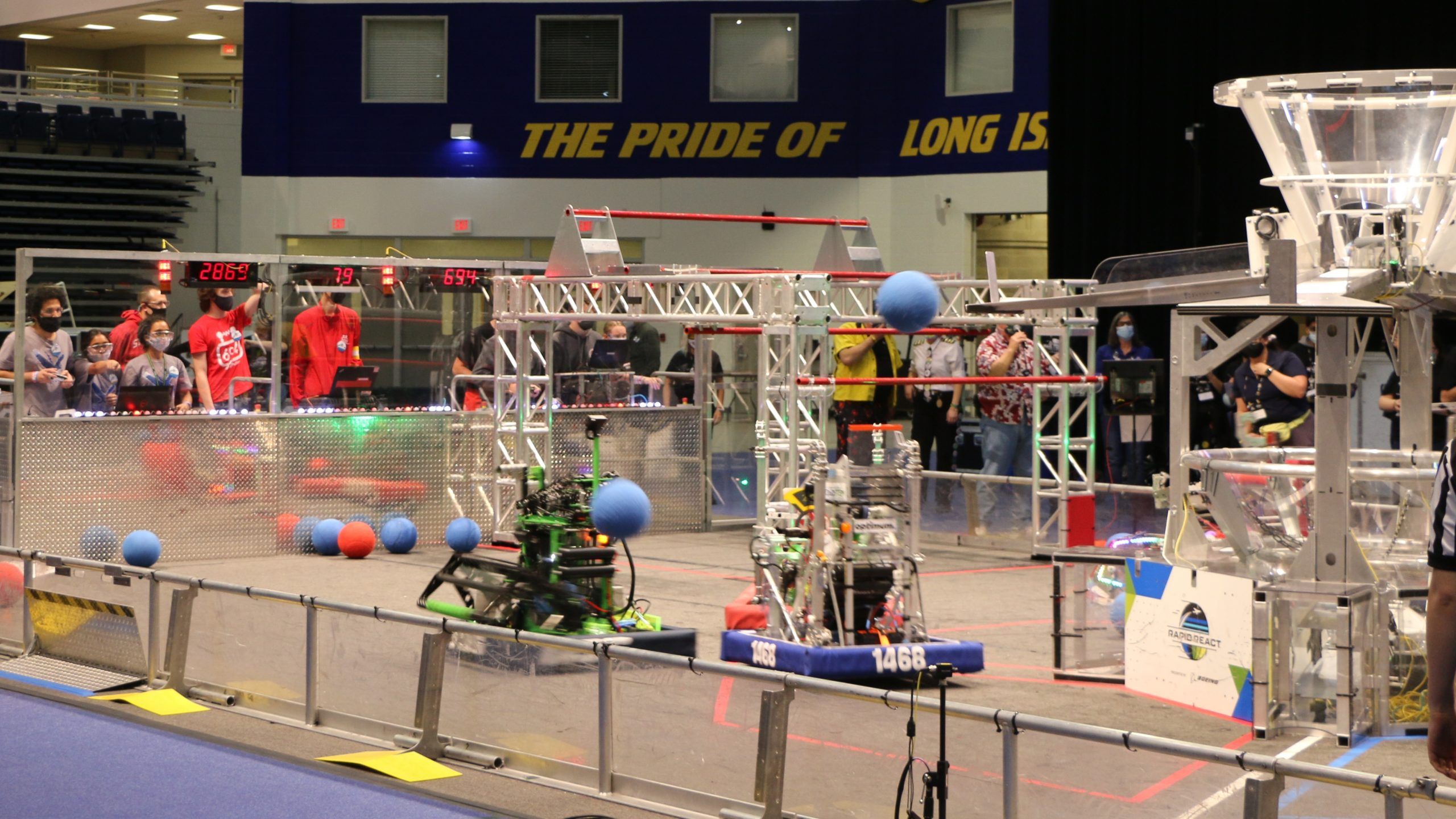 Blue Alliance robots from Team #1796 “RoboTigers” from Queens Technical High School and Team #1496 “Hicksville J-Birds” from Hicksville High School attempt to score their cargo into the hub during the finals of the 2022 SBPLI Long Island Regional #2.