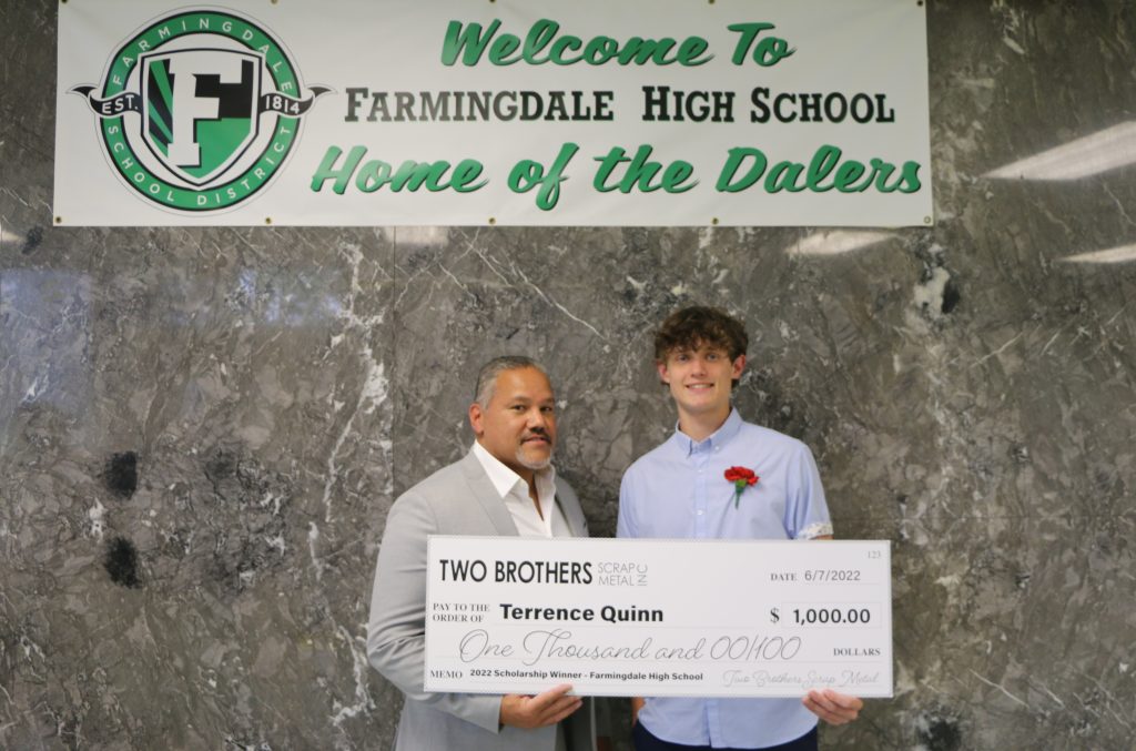 Two Brothers Scrap Metal Manager Mark Santiago (left) presents the scholarship check to Terrence Quinn (right), a senior at Farmingdale High School.