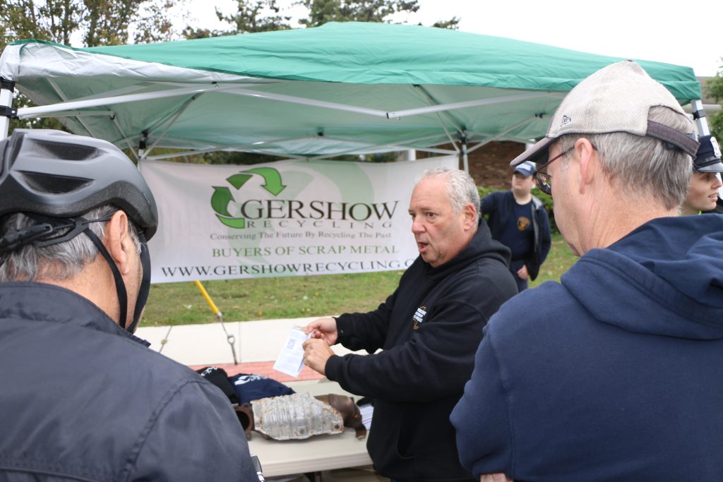 Lawrence Schillinger, compliance counsel for the Institute of Scrap Recycling Industries (ISRI), explains to visitors how the anti-theft marking/etching kits for catalytic converters are used during St. James Day on October 2. Gershow Recycling joined ISRI and the Suffolk County Police Department in distributing these kits.