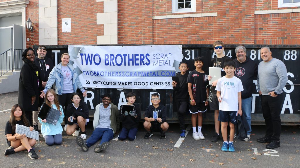 Students from Mineola Middle School pose with some of the electronic devices they collected during their sixth annual eWaste Drive on October 28. They are joined by Mineola Middle School Instructional Leader Racquel Stephenson (back row, left), Dean of Students Steven Benner (back row, second from left), Principal Amy Trojanowski (back row, third from left), Robotics Club Moderator Vincent Interrante (second from right), and Two Brothers Scrap Metal Manager Mark Santiago (back row, right).