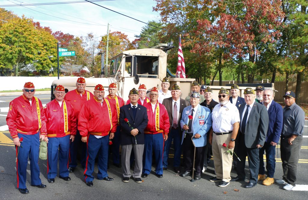 Islandia Village Mayor Allan M. Dorman (front row, center) is joined by members of the United States Marine Corps and Col. Francis S. Midura Veterans of Foreign Wars Post #12144 and village board members in front of a U.S. Marine Corps vehicle during the Village’s Veterans Day ceremony.