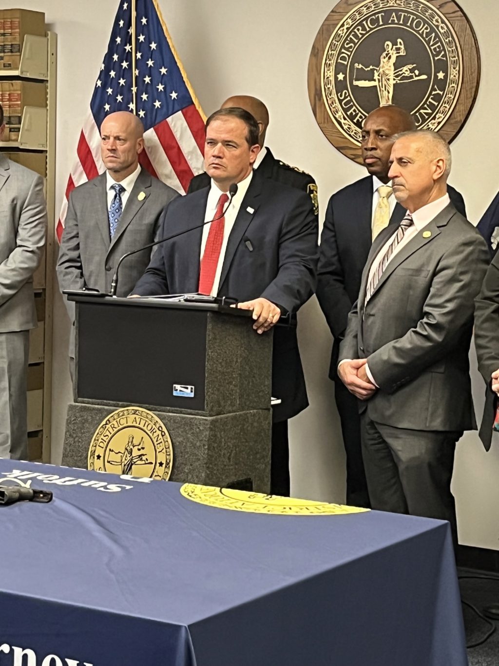 Photo by Shannon Wilson/Office of Suffolk County District Attorney Ray Tierney
Suffolk County District Attorney Ray Tierney (standing behind podium) takes questions during a press conference on December 12 announcing the indictment of 18 alleged gang members.