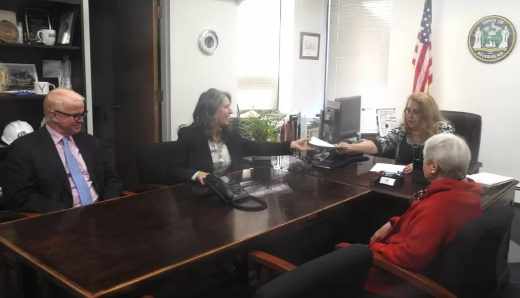 (Photo: Town of Riverhead) 
Supervisor Yvette Aguiar (second from right) and PBMC Foundation Executive Director and President Amy Loeb (second from left) exchange paperwork in connection with the Town’s purchase of PBMC’s Entenmann Campus on 2nd Street.