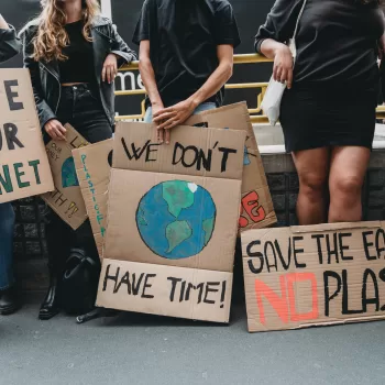 People are holding banner signs while they are going to a demonstration against climate change. Protest against global warming. Climate change protest concept.