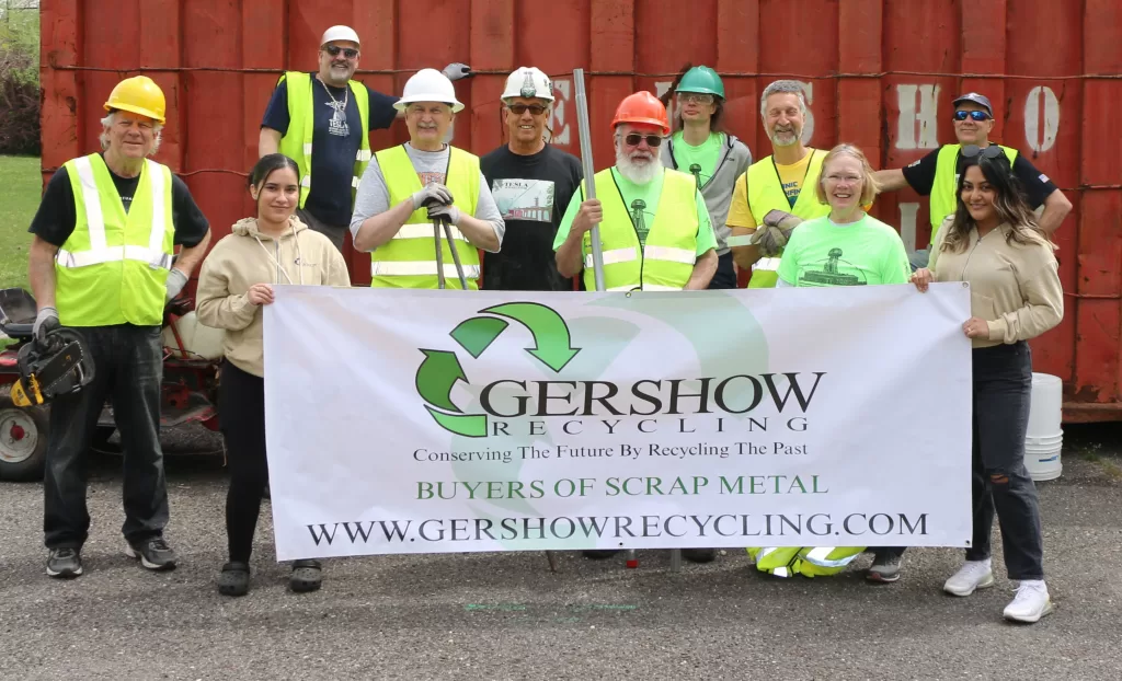 Gershow Recycling Logistics Coordinator Khaliah Vega-Bellone (front row, second from left) and Call Center Representative Keily Nolasco (right) are joined by members of the Tesla Science Center at Wardenclyffe (TSCW) during the “Metal for Tesla” fundraising event on April 22. Also pictured (front row, l-r): Facilities & Grounds Team Member Dan Berry; Board Member/Facilities & Grounds Team Member Gene Genova, and Facilities & Grounds Team Members Bill Haydamach and Judy Black. Back row (l-r): Facilities & Grounds Team Members Peter Palmieri, Tom LeDeoux, Steve Kuhl, Jeff Brown, and Jim Wuttke.