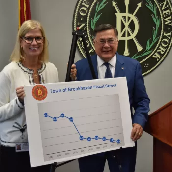 (Photo: Town of Brookhaven) Brookhaven Town Board Member Jane Bonner (left) and Town Supervisor Ed Romaine (right) display a chart showing a perfect fiscal stress score from the New York State Comptroller's Office.