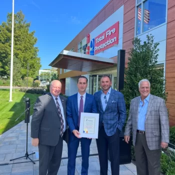 (Photo: Office of Legislator Arnold W. Drucker and Total Fire Protection) Nassau County Legislator Arnold Drucker (left) is joined by the principals of Total Fire Protection as the company celebrates the grand opening of its new headquarters in Woodbury on September 20.