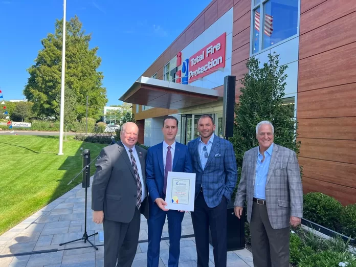 (Photo: Office of Legislator Arnold W. Drucker and Total Fire Protection) Nassau County Legislator Arnold Drucker (left) is joined by the principals of Total Fire Protection as the company celebrates the grand opening of its new headquarters in Woodbury on September 20.