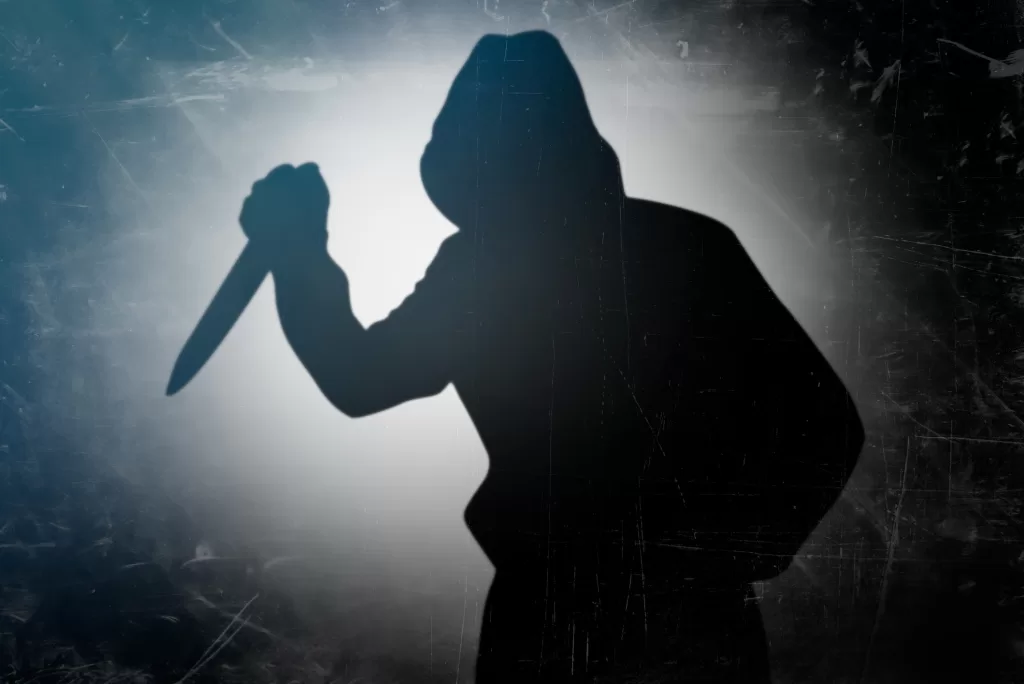 Shadow of the murderer holding the murder weapon. Silhouette of man with a knife in his hand