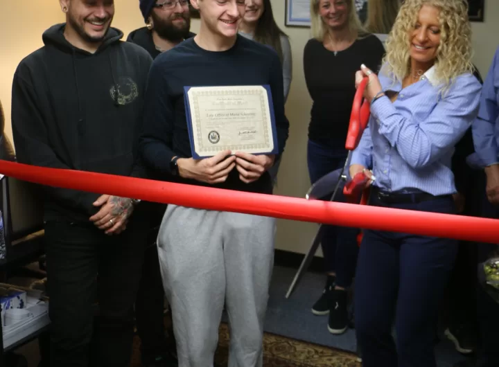 (Photo by Hank Russell) Maria Scheuring (right) prepares to cut the ribbon in celebration of her new office at 1 South Ocean Avenue, Suite 204A, in Patchogue. She is joined by Ron Ulip (left), the owner of Freshly Cut Films, and her son Maddox (center).