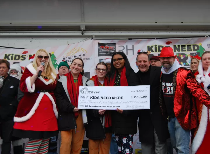 KiDS NEED MoRE President/Founder Melissa Firmes, LMSW (left) announces the donation from Gershow Recycling during the organization's Holiday Cheer Elf Ride in Amityville on December 17. Also pictured with the elves from the Sleigh All The Way team, which was supported by Gershow, are Jonathan Abrams of Gershow (second from right) and KiDS NEED MoRE Treasurer John Ray (right).