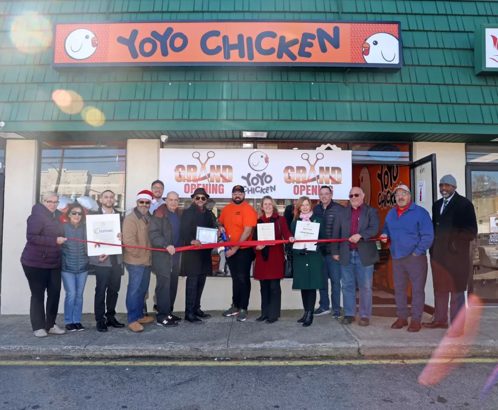(Photo: Office of Legislator Debra Mulé) Nassau County Legislator Debra Mulé (sixth from right) joins in the ribbon cutting of the new YoYo Chicken restaurant in Baldwin on December 20.