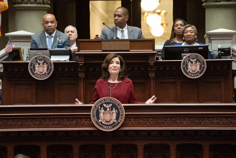 CAPTION:
(Photo: Office of Governor Kathy Hochul) New York Governor Kathy Hochul (behind podium)
speaks at the State of the State address on January 9. She is flanked by (left to right) Assembly
Speaker Carl Heastie, Comptroller Thomas DiNapoli, Lieutenant Governor Antonio Delgado,
Attorney General Letitia James and Senate Majority Leader Andrea Stewart-Cousins.