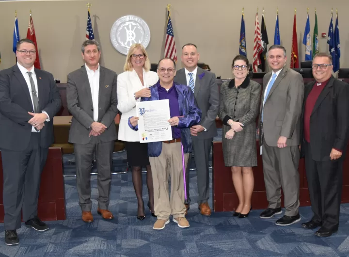 (Photo: Town of Brookhaven) Frank Rivera presents the proclamation presented to him by the Brookhaven Town Board at its April 4 meeting. Also pictured (left to right) are Councilman Neil Manzella; Councilmember Jonathan Kornreich; Councilwoman Jane Bonner; Supervisor Dan Panico; Councilmember Karen Dunne Kesnig; Town Clerk Kevin LaValle and Councilman Michael Loguercio.