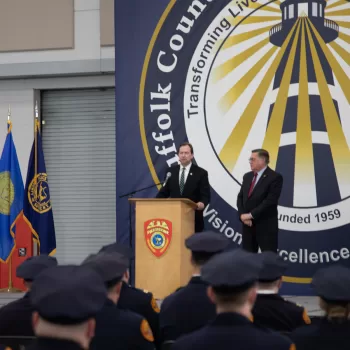 (Photo Courtesy of SCPD) Suffolk County Acting Police Commissioner Robert Waring (standing behind podium) addresses the police officers while County Executive Ed Romaine looks on.
