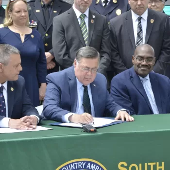 (Photo: Suffolk County Legislature) Suffolk County Executive Ed Romaine signs into law Suffolk Legislator Dominick
Thorne’s bill designating the third week in May 2024, and every year thereafter, as “EMS
Appreciation Week” in Suffolk County. At table, Romaine (center) is flanked by Thorne (left) and
Suffolk Department of Heath Services Commissioner Gregson H. Pigott, MD, MPH (right). They
were joined at the South Country Ambulance Company HQ in Bellport, NY, by members of over
twenty EMS agencies from across Suffolk County.