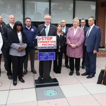 (Photo: Town of Hempstead) Hempstead Town Supervisor Dan Clavin (behind podium) is joined by town and other elected officials to announce a lawsuit against the MTA and the Federal Highway Administration over the congestion pricing plan.