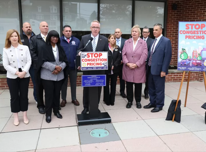 (Photo: Town of Hempstead) Hempstead Town Supervisor Dan Clavin (behind podium) is joined by town and other elected officials to announce a lawsuit against the MTA and the Federal Highway Administration over the congestion pricing plan.