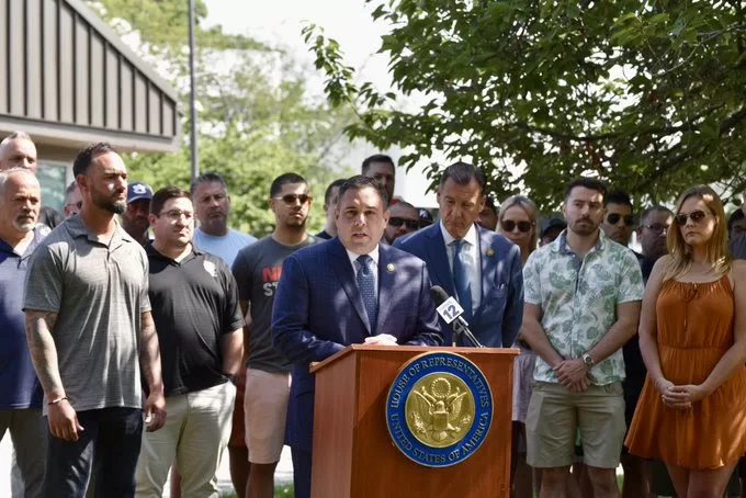 (Photo: Office of Anthony D'Esposito) U.S. Congressman Anthony D'Esposito (behind podium) rallied to keep 17 air traffic controller jobs in Westbury, along with Tom Suozzi (behind D'Esposito's left).