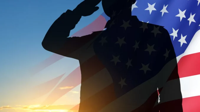 Silhouette of soldier with USA flag against the sunset