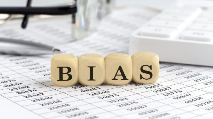 wooden cubes with the word BIAS on a financial background with chart, calculator, pen and glasses, business concept.