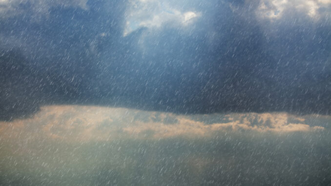 Sunlight Piercing Through Rain Clouds, Illuminating the Sky with a Soft Glow Amid the Gloom