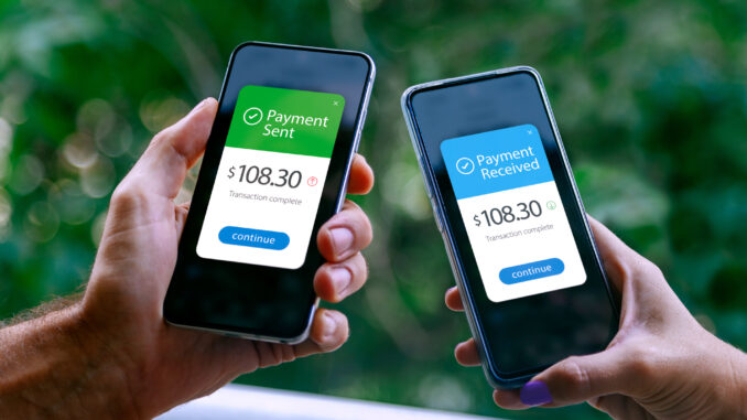 Two smartphones held by a woman and a man showing sending and receiving payments through a digital wallet application on a mobile phone. Bank transfer concept. Digital money.