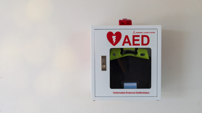 Automated External Defibrillator medical first aid device on white wall.AED box.